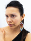 Boucles d'oreilles artisanales Marron, Orange & Blanc Taille M. Tradition Colombie. Porté