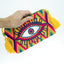 Pochette Soleico Clutch Wayuu avec Motif Oeil brodé Mauve Vert. Fait main motif Evil Eye. Artisanat Ethnique Responsable. Modèle similaire Enayim design Sac Colombien